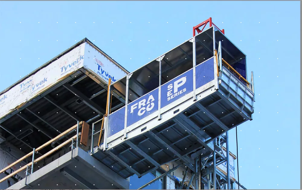 A transport platform is used to move workers safely up and down the outside of a building under construction.