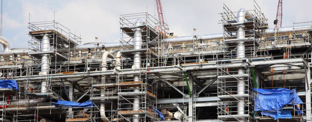 Scaffolding is seen built around pipework at a oil drilling platform.