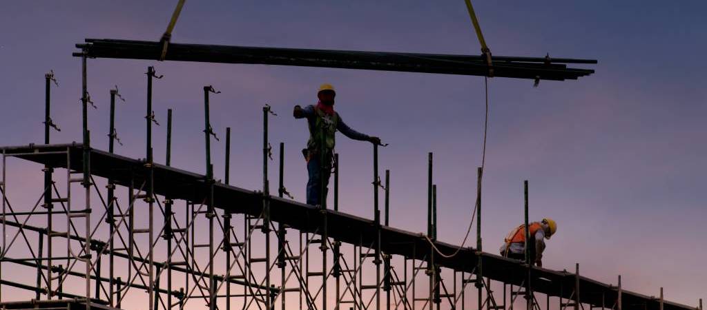 Contractors working while standing on scaffolding