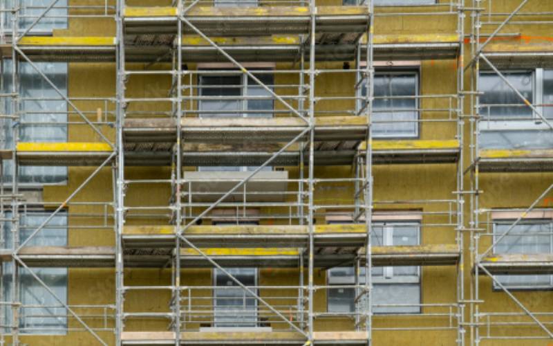 Scaffolding around a building with recently installed insulation